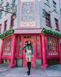 a woman standing in front of a red building