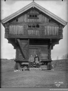 two people sitting in front of a wooden cabin