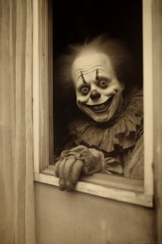 a creepy looking clown looks out the window