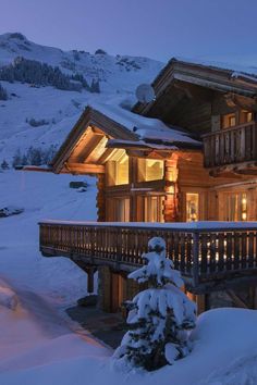 a house is lit up in the snow