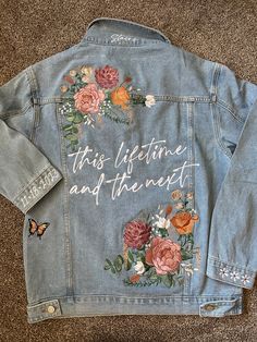 a jean jacket with embroidered flowers on it that says, this lifetime and the rest