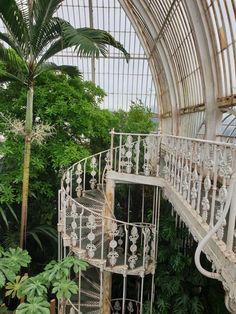 an old spiral staircase in the middle of a tropical garden