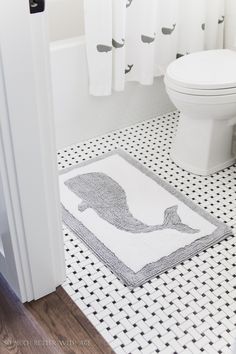 a white toilet sitting next to a bath tub in a bathroom under a shower curtain