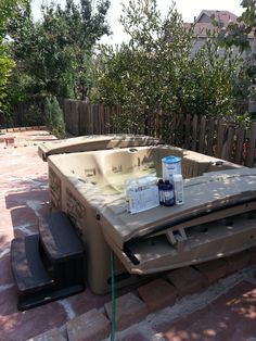 an outdoor hot tub in the middle of a brick patio