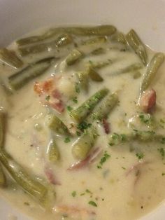 a white bowl filled with soup and green beans