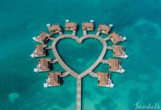 an aerial view of a heart - shaped pier in the middle of the ocean with houses built into it