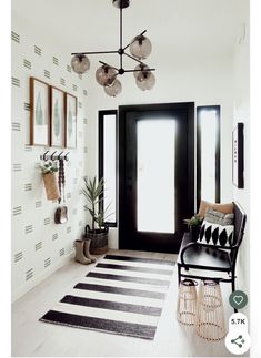 a black and white striped rug in front of a door with hanging lights above it