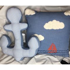 a blue and white pillow sitting on top of a bed next to a stuffed animal