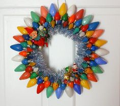 a wreath with christmas lights hanging on the front door