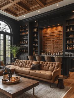 a living room filled with furniture and lots of shelves full of bottles on top of them