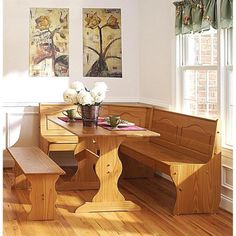 a wooden table with two benches next to it and flowers in a vase on the table