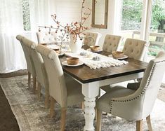 the dining room table is set with white chairs