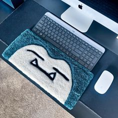 a computer keyboard sitting on top of a blue rug next to a mouse and keyboard