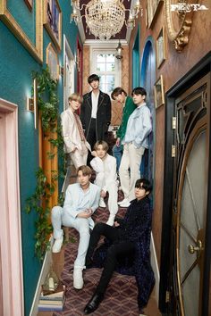 a group of young men standing on the stairs in front of an entrance to a house