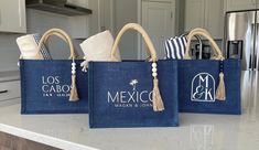 three blue bags with tassels on them sitting on a counter top in a kitchen