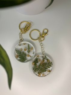 two key chains with plants and leaves on them