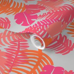 an orange and pink tropical print wallpaper with leaves on the side, along with a roll of tape