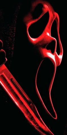 a knife with red light coming out of it's blade, in front of a black background