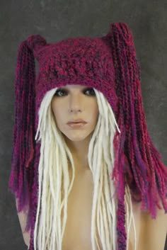 a mannequin wearing a knitted hat with white dreadlocks and purple yarn