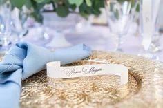 a close up of a plate on a table with napkins and glasses in the background