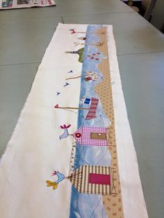 the long table runner is decorated with colorful fabric and thread work on it's edges