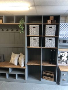 a room filled with lots of gray shelves and white baskets on top of it's sides