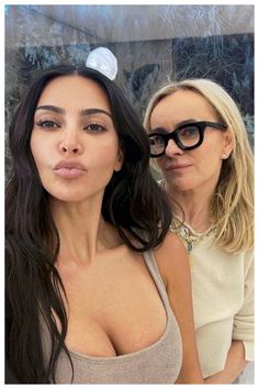 two women are posing for the camera with one woman sticking her tongue out and wearing glasses