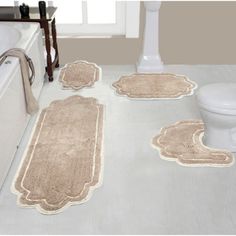 bathroom rugs and bath mats on the floor in front of a toilet