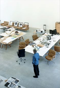 a man standing in an office looking at desks