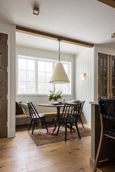 a dining room table with four chairs and a lamp