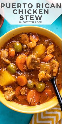 a yellow bowl filled with stew and vegetables on top of a blue tablecloth next to a