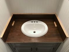 a white sink sitting on top of a wooden counter