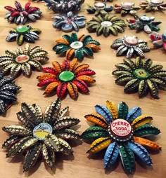 there are many different colored brooches on the wooden table with each one's own name