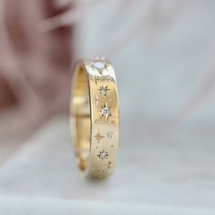 a gold wedding band with stars and diamonds on the inside, set in 18k yellow gold