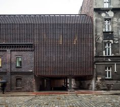 an old building that has been made out of bricks and is in the middle of a cobblestone street