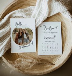 two wedding save the dates cards sitting on top of a wooden bowl