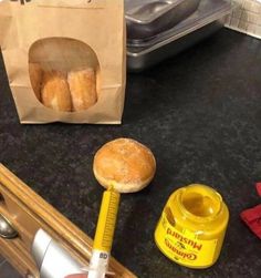 two donuts are sitting on the counter next to a measuring tape and a bag