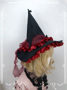 a wig wearing a black and red hat with ruffles on the top,