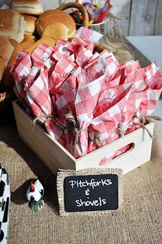 there is a wooden box filled with red and white napkins next to other food items