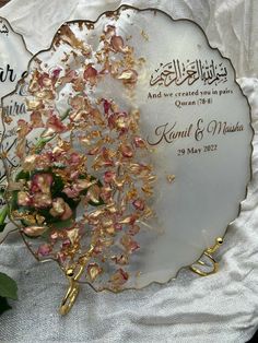 a white plate with flowers on it sitting next to a green plant and two other items