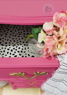 a pink box with flowers in it sitting on a table