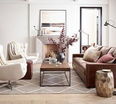 a living room with couches, chairs and a fire place in the center area