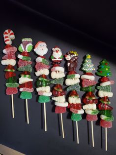 christmas candy lollipops with santa hats and stockings on them are lined up