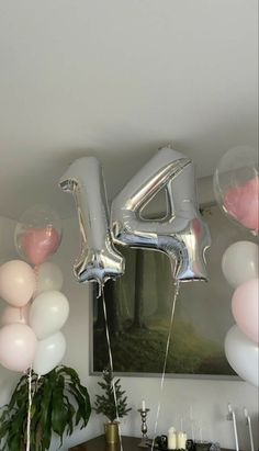 balloons and streamers in the shape of letters are hanging from the ceiling above a dining room table