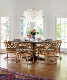 a dining room table with chairs and a chandelier hanging from it's ceiling