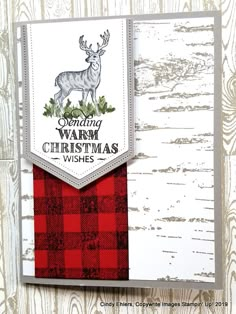 a close up of a christmas card on a wooden background with the words sending warm christmas wishes