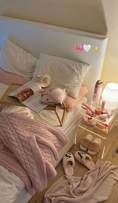 there is a bed with pink blankets and slippers on the floor next to it