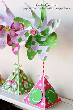 three colorful paper hats on top of a white shelf with polka dots and green leaves