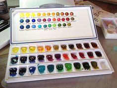 an open box of watercolor paints on a table