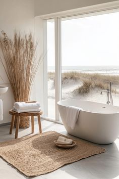 a white bath tub sitting on top of a bathroom floor next to a large window